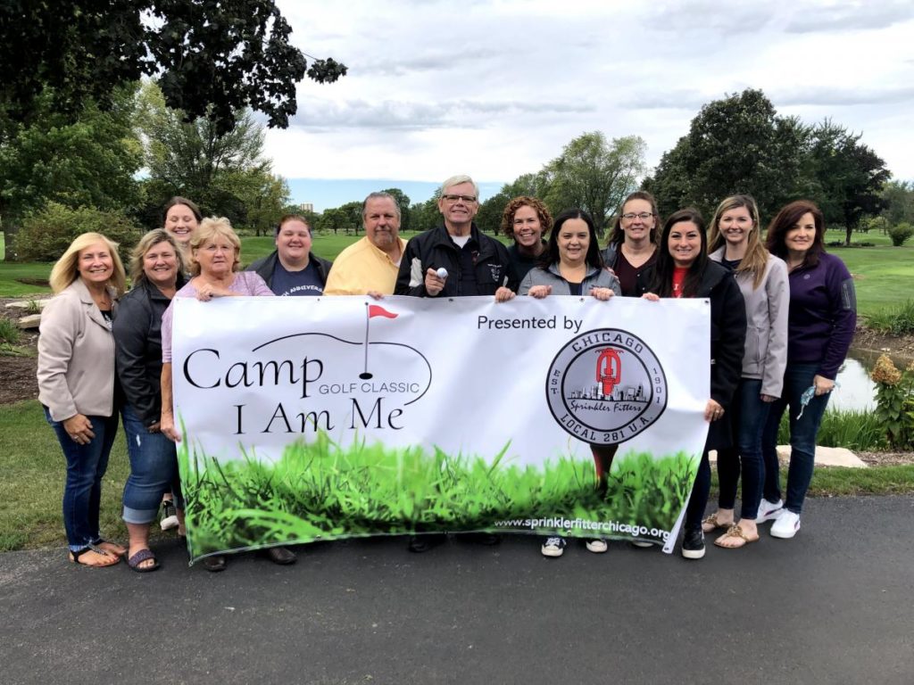 Group holding up banner sign for Camp I Am Me Golf Classic